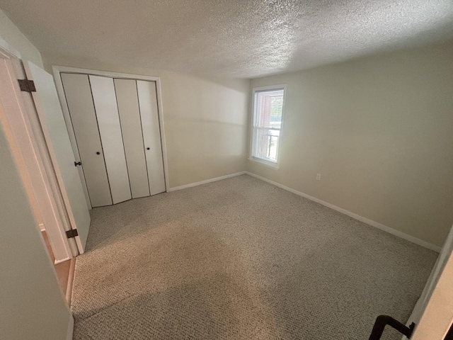 112 W 6th St, Gridley, IL 61744 - unfurnished bedroom featuring a textured ceiling, a closet, and carpet