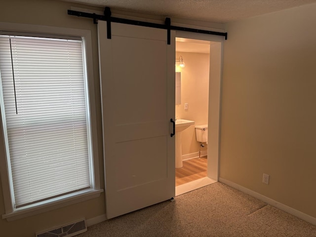 112 W 6th St, Gridley, IL 61744 - unfurnished bedroom with carpet, a barn door, and ensuite bathroom
