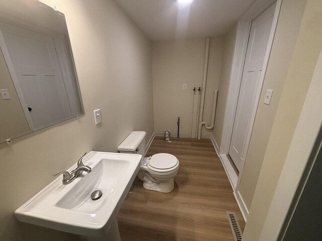 112 W 6th St, Gridley, IL 61744 - half bathroom featuring toilet and wood finished floors