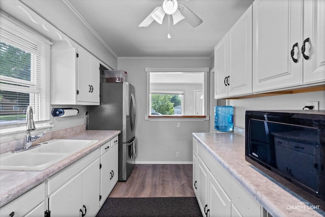 424 Howard Ave, Aurora, IL 60506 - kitchen featuring a sink, black microwave, white cabinets, dark wood finished floors, and light countertops