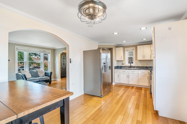 3829 S Austin Blvd, Cicero, IL 60804 - kitchen with stainless steel appliances, arched walkways, ornamental molding, light wood-style floors, and dark countertops