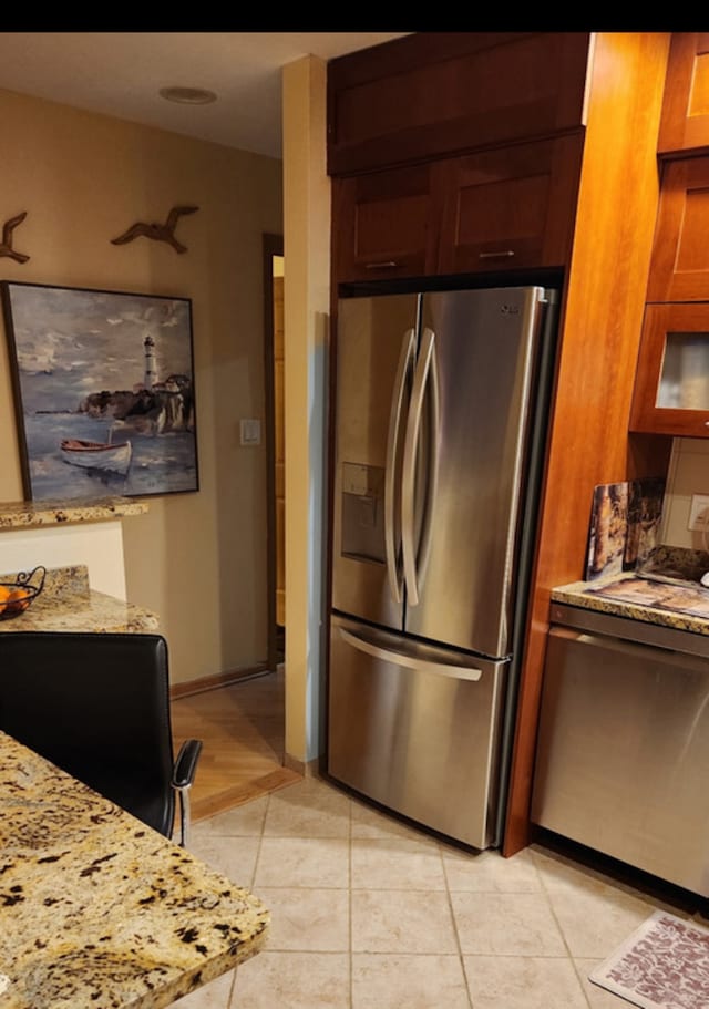 3300 N Carriageway Dr Unit 209, Arlington Heights, IL 60004 - kitchen featuring appliances with stainless steel finishes, light stone countertops, light tile patterned floors, and baseboards