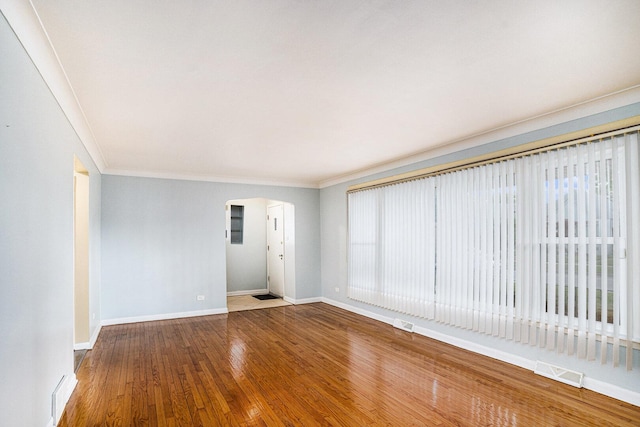 12101 S Lafayette Ave, Chicago, IL 60628 - spare room featuring baseboards, wood finished floors, arched walkways, and crown molding