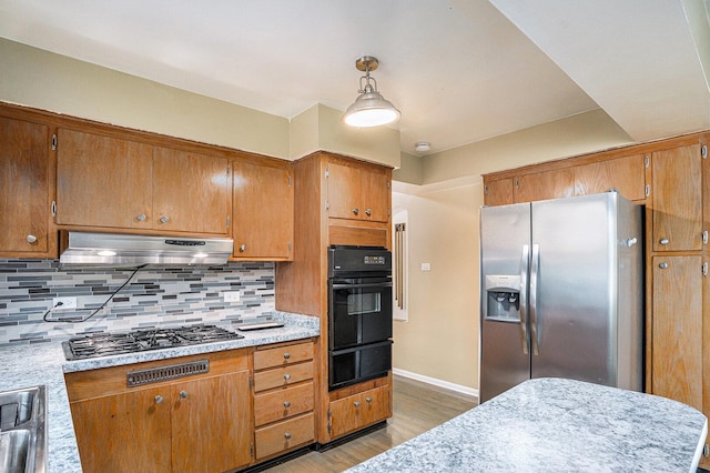12101 S Lafayette Ave, Chicago, IL 60628 - kitchen featuring appliances with stainless steel finishes, a warming drawer, light wood-style flooring, under cabinet range hood, and tasteful backsplash