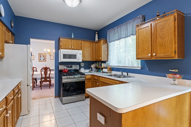 2107 Vermette Cir, Plainfield, IL 60586 - kitchen with white appliances, light countertops, light tile patterned floors, a peninsula, and brown cabinetry