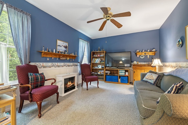 2107 Vermette Cir, Plainfield, IL 60586 - carpeted living room with a ceiling fan, wainscoting, and a warm lit fireplace