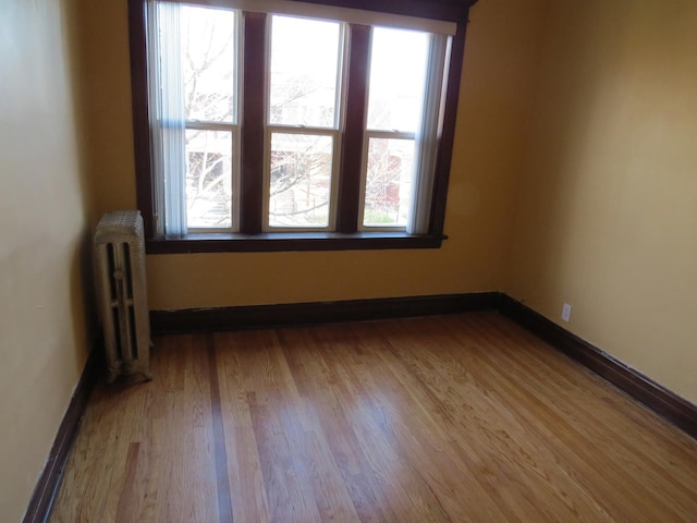 7120 S Eberhart Ave, Chicago, IL 60619 - spare room featuring radiator heating unit, wood finished floors, and baseboards