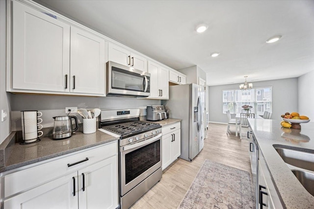 3808 Honeysuckle Ln, Elgin, IL 60124 - kitchen with stainless steel appliances, white cabinetry, stone counters, a chandelier, and light wood-type flooring