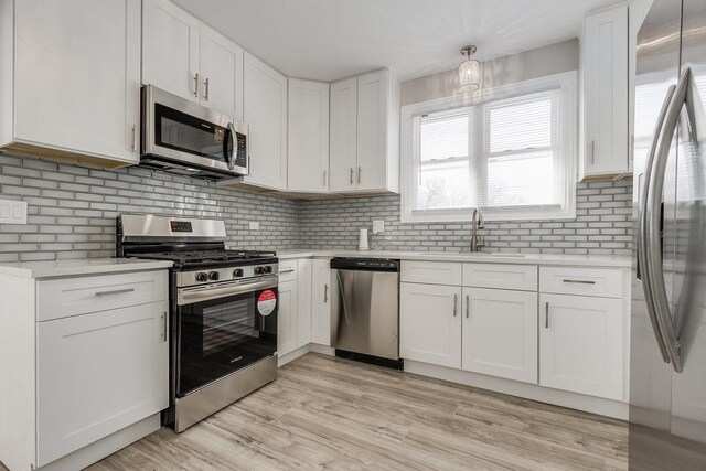 12533 S Lowe Ave, Chicago, IL 60628 - kitchen with appliances with stainless steel finishes, a sink, white cabinetry, light countertops, and backsplash