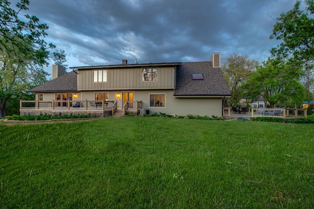 6517 Saddle Ridge Ct, Long Grove, IL 60047 - rear view of property featuring a chimney, a wooden deck, a yard, board and batten siding, and roof with shingles