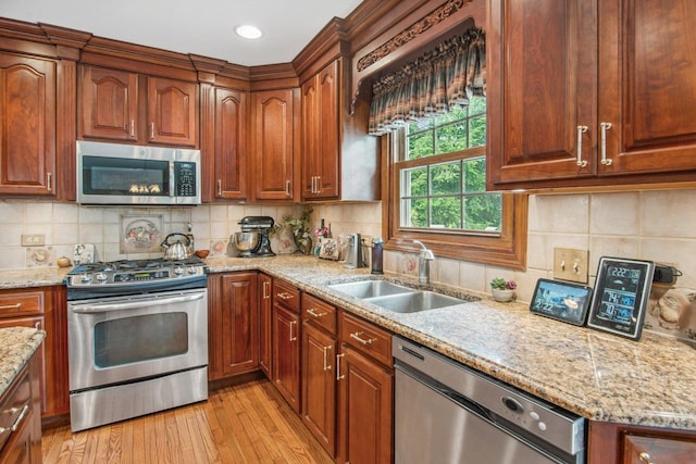 5N647 Forest Glen Ln, Saint Charles, IL 60175 - kitchen featuring stainless steel appliances, a sink, light wood finished floors, light stone countertops, and decorative backsplash