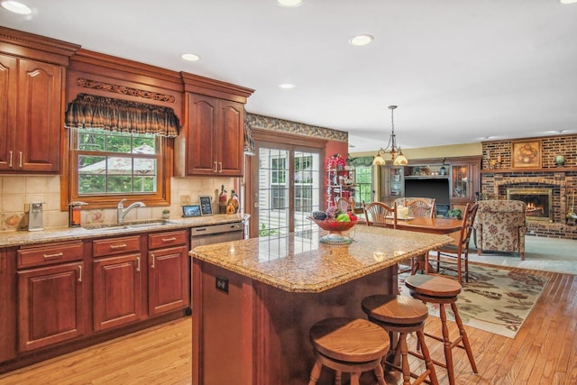 5N647 Forest Glen Ln, Saint Charles, IL 60175 - kitchen with a sink, light wood-style floors, a kitchen breakfast bar, a center island, and light stone counters
