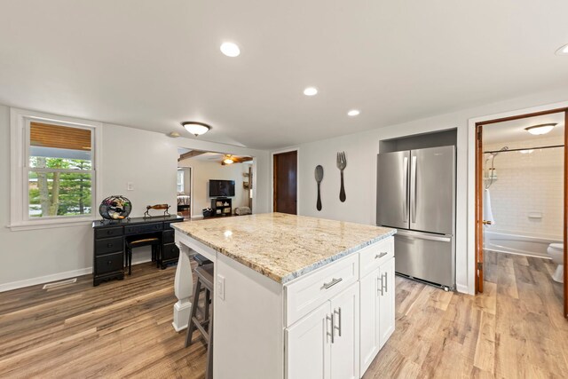 17811 Harwood Ave, Homewood, IL 60430 - kitchen with freestanding refrigerator, a center island, light stone counters, white cabinets, and light wood finished floors