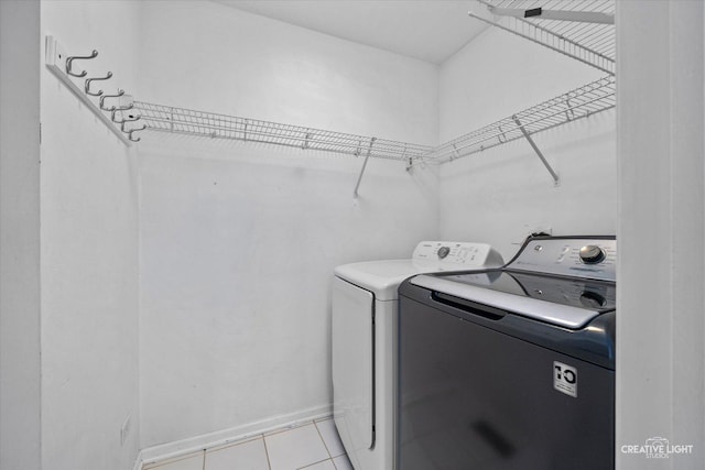 2724 Bluewater Cir, Naperville, IL 60564 - laundry room featuring washing machine and clothes dryer, light tile patterned floors, and baseboards
