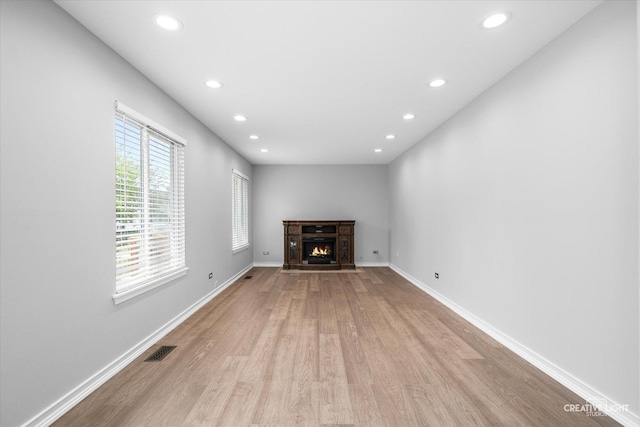 2724 Bluewater Cir, Naperville, IL 60564 - unfurnished living room featuring light wood-style floors, recessed lighting, baseboards, and a lit fireplace
