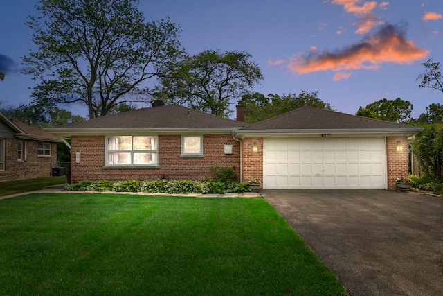 1717 Dundee Rd, Northbrook, IL 60062 - view of front of house featuring asphalt driveway, a chimney, brick siding, a front yard, and a garage