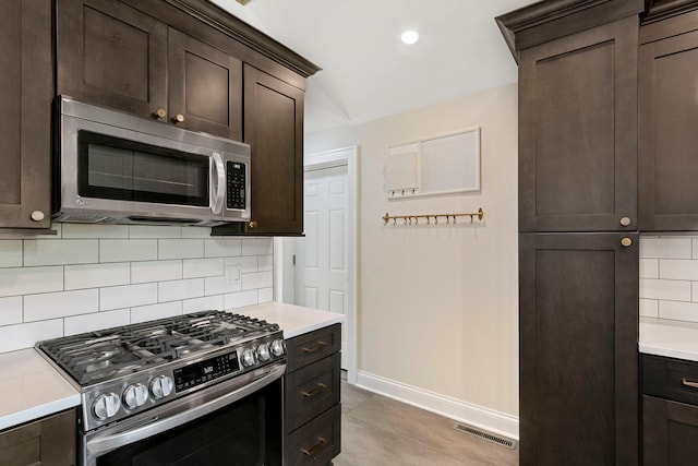1717 Dundee Rd, Northbrook, IL 60062 - kitchen with appliances with stainless steel finishes, baseboards, dark brown cabinetry, decorative backsplash, and light countertops