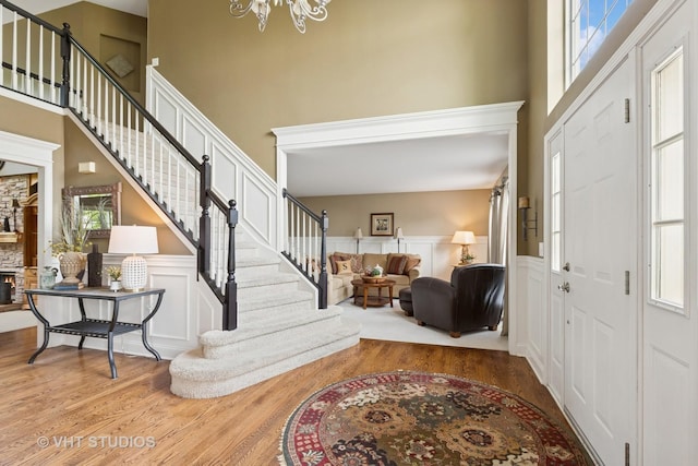 36932 N Fernview Ln, Lake Villa, IL 60046 - entrance foyer featuring wood finished floors, stairs, a chandelier, a towering ceiling, and a decorative wall