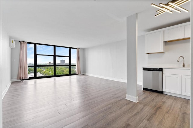 2901 S Michigan Ave Unit 903, Chicago, IL 60616 - unfurnished living room with a sink, floor to ceiling windows, light wood-style flooring, and baseboards