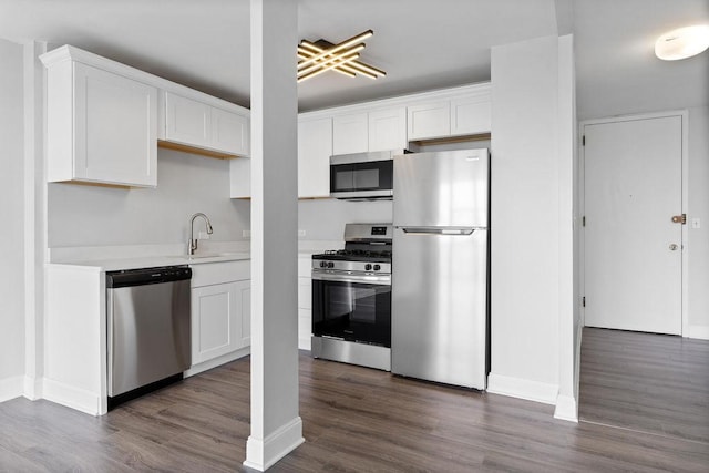 2901 S Michigan Ave Unit 903, Chicago, IL 60616 - kitchen with stainless steel appliances, a sink, dark wood-style flooring, light countertops, and baseboards