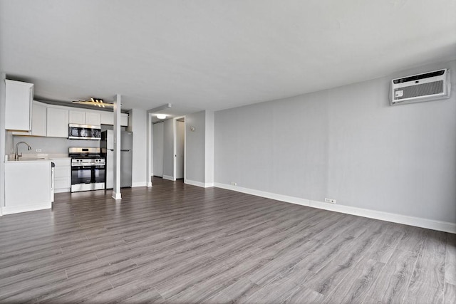 2901 S Michigan Ave Unit 903, Chicago, IL 60616 - unfurnished living room with an AC wall unit, a sink, and wood finished floors