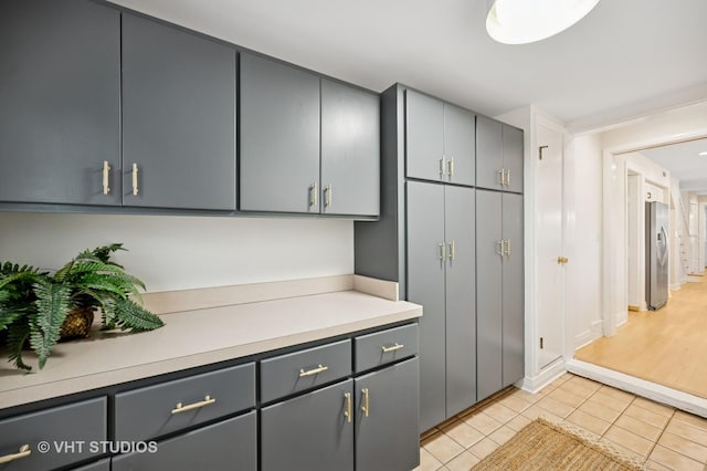 630 Juniper Rd, Glenview, IL 60025 - kitchen featuring stainless steel fridge, light countertops, light tile patterned floors, and gray cabinets