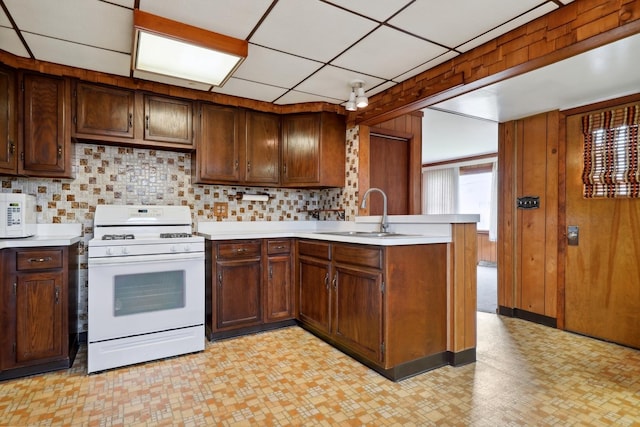4612 W 89th Pl, Hometown, IL 60456 - kitchen with white gas range, a peninsula, light floors, light countertops, and a sink
