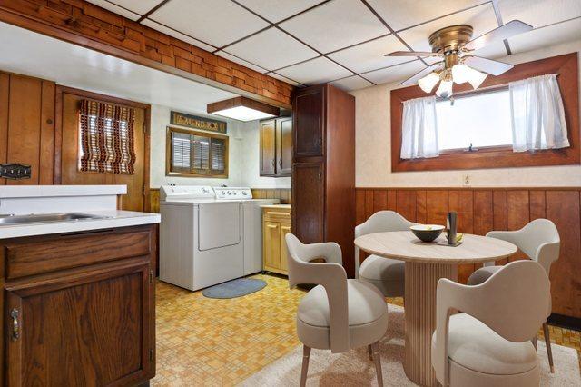 4612 W 89th Pl, Hometown, IL 60456 - dining area with separate washer and dryer, wooden walls, ceiling fan, a wainscoted wall, and light flooring
