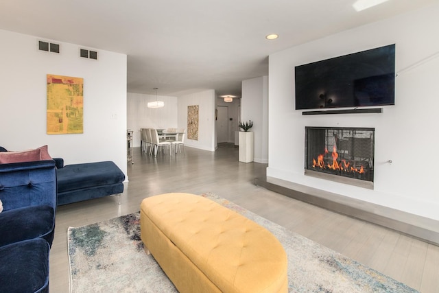 125 Boardwalk Pl Unit 101, Park Ridge, IL 60068 - living area featuring wood finished floors, a glass covered fireplace, recessed lighting, and baseboards