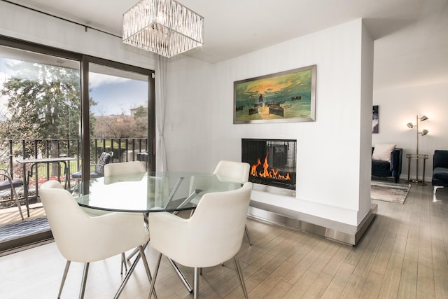 125 Boardwalk Pl Unit 101, Park Ridge, IL 60068 - dining space with a glass covered fireplace, wood finished floors, baseboards, and a chandelier