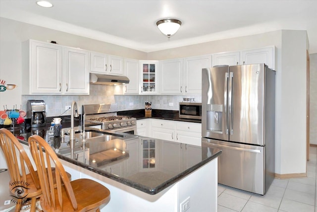 1360 Pheasant Chase Cir, Beecher, IL 60401 - kitchen featuring appliances with stainless steel finishes, under cabinet range hood, a peninsula, glass insert cabinets, and decorative backsplash