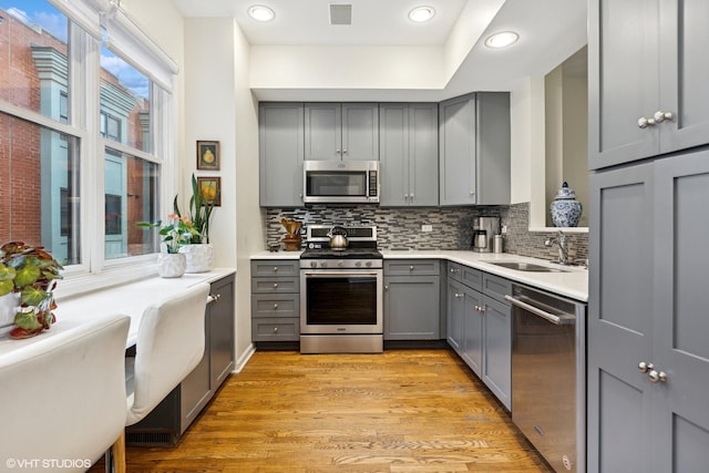 5844 N Hermitage Ave Unit A, Chicago, IL 60660 - kitchen with gray cabinets, appliances with stainless steel finishes, a sink, tasteful backsplash, and light countertops