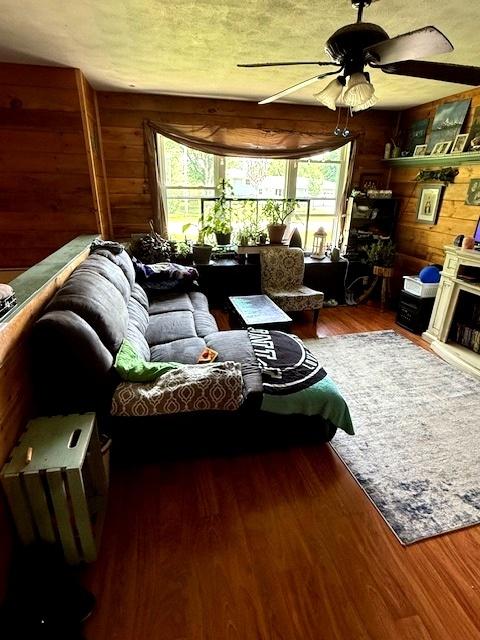 29478 E County Road 2390th Rd, Manito, IL 61546 - living room featuring a ceiling fan, wood finished floors, and wooden walls