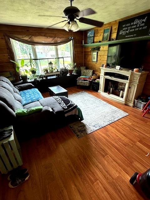 29478 E County Road 2390th Rd, Manito, IL 61546 - living area featuring a ceiling fan, wood walls, wood finished floors, and a large fireplace