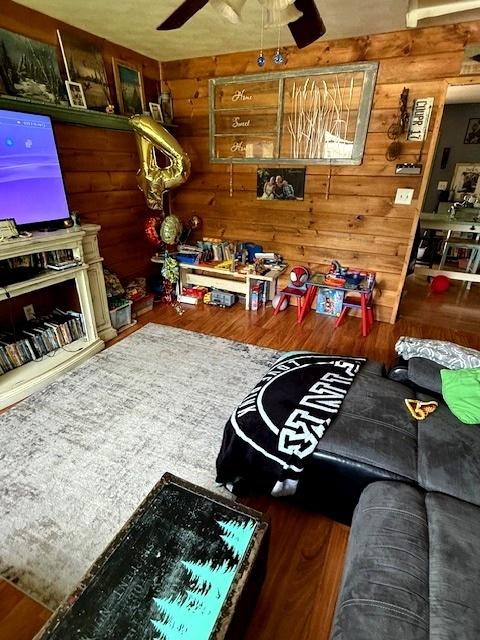 29478 E County Road 2390th Rd, Manito, IL 61546 - living area featuring a ceiling fan, wood finished floors, and wooden walls