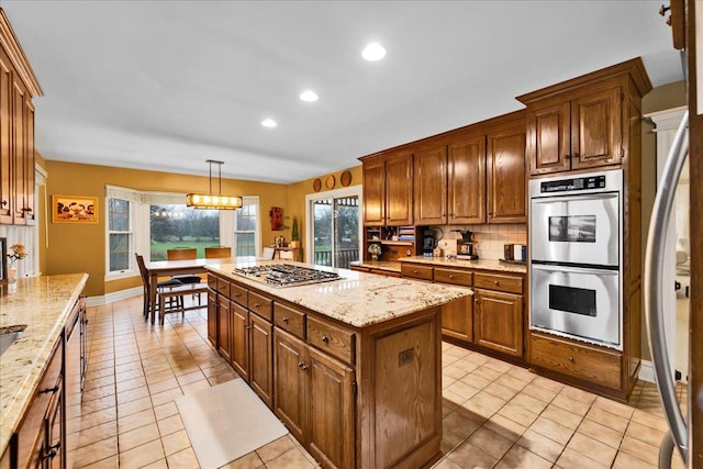 3838 Plainfield Rd, Oswego, IL 60543 - kitchen with appliances with stainless steel finishes, a kitchen island, light tile patterned floors, recessed lighting, and brown cabinetry