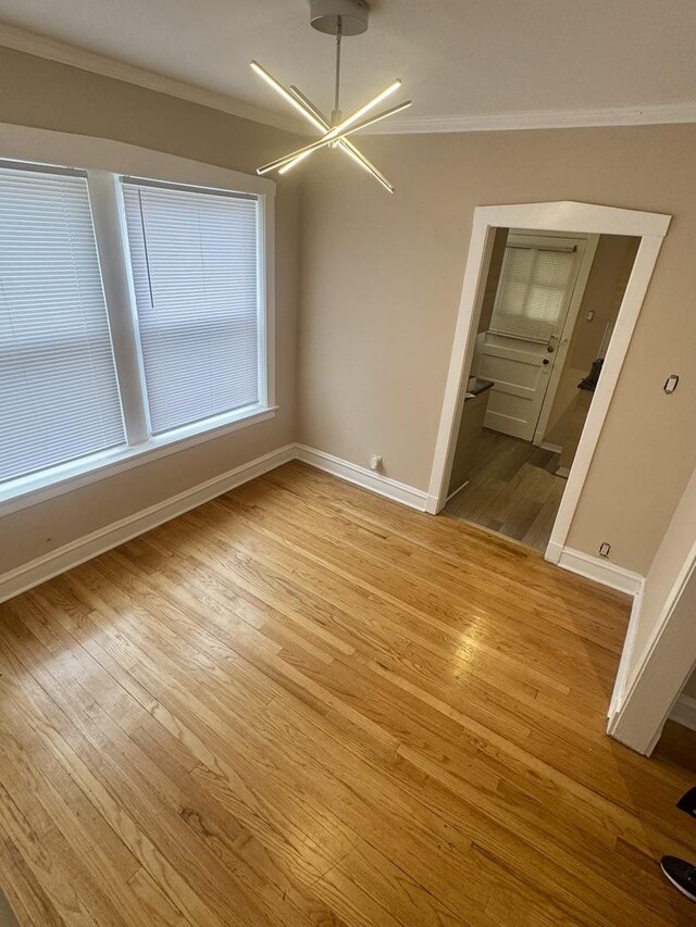 6638 S Greenwood Ave Unit 2B, Chicago, IL 60637 - spare room with ornamental molding, light wood finished floors, baseboards, and a chandelier