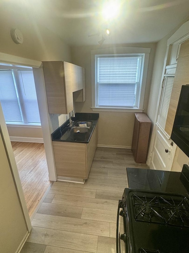 6638 S Greenwood Ave Unit 2B, Chicago, IL 60637 - kitchen with light wood-style floors, a sink, gas stove, baseboards, and dark countertops