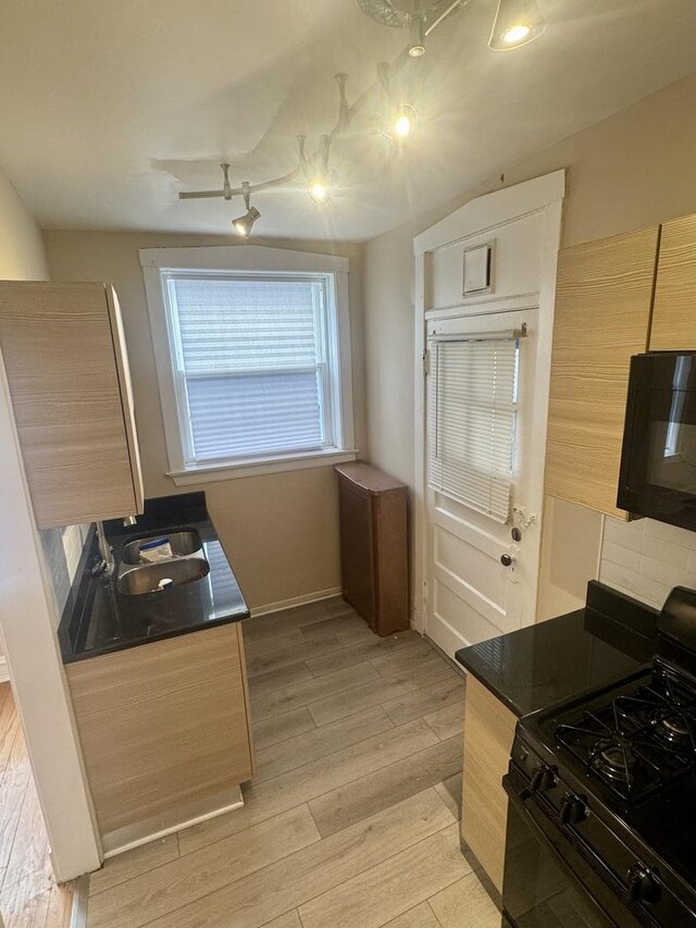 6638 S Greenwood Ave Unit 2B, Chicago, IL 60637 - kitchen featuring black appliances, a sink, light wood-type flooring, and dark countertops
