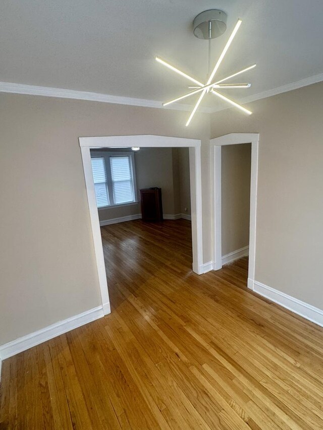 6638 S Greenwood Ave Unit 2B, Chicago, IL 60637 - spare room with ornamental molding, baseboards, light wood-style flooring, and a chandelier