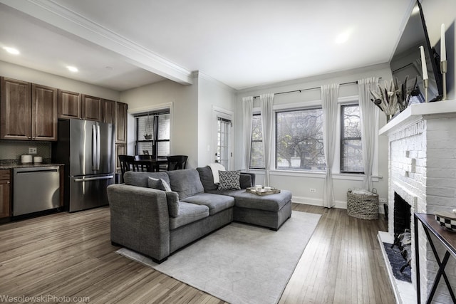 4005 N Southport Ave Unit 2, Chicago, IL 60613 - living area with a brick fireplace, healthy amount of natural light, light wood finished floors, crown molding, and recessed lighting