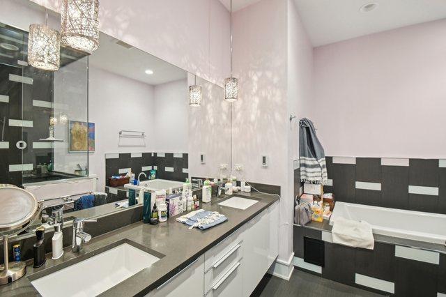 2424 W Chicago Ave Unit 202, Chicago, IL 60622 - full bathroom featuring a bath, double vanity, a stall shower, wood finished floors, and recessed lighting