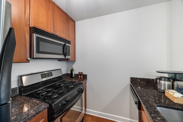 1400 S Michigan Ave Unit 707, Chicago, IL 60605 - kitchen with appliances with stainless steel finishes, baseboards, brown cabinets, and dark stone counters