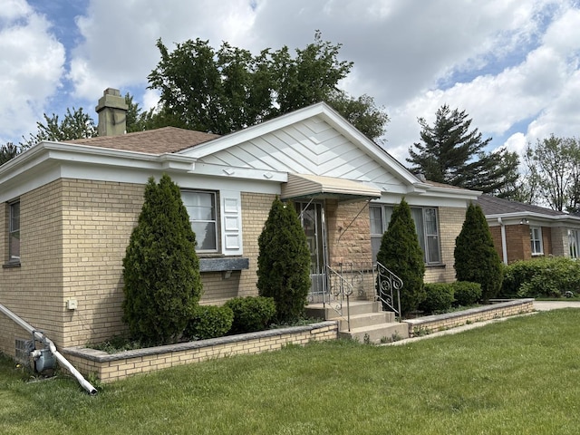 11138 Shaw St, Westchester, IL 60154 - view of front facade with a chimney, brick siding, and a front lawn