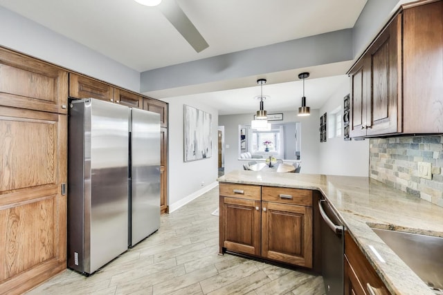 5004 N Knight Ave, Norridge, IL 60706 - kitchen with appliances with stainless steel finishes, a peninsula, tasteful backsplash, light stone countertops, and pendant lighting