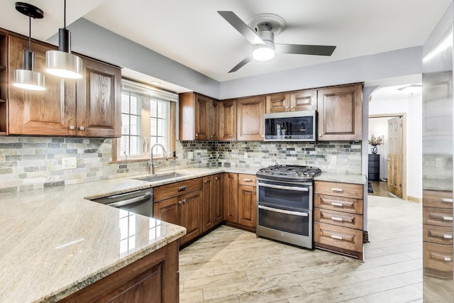 5004 N Knight Ave, Norridge, IL 60706 - kitchen featuring appliances with stainless steel finishes, a sink, a ceiling fan, light stone countertops, and decorative backsplash