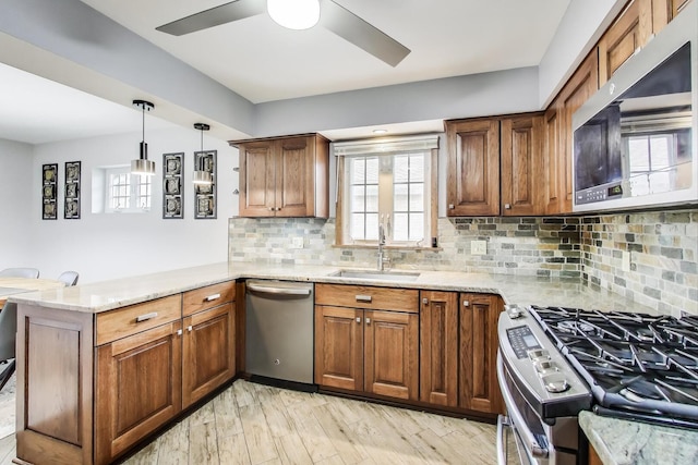 5004 N Knight Ave, Norridge, IL 60706 - kitchen with stainless steel appliances, a sink, a peninsula, ceiling fan, and light stone counters