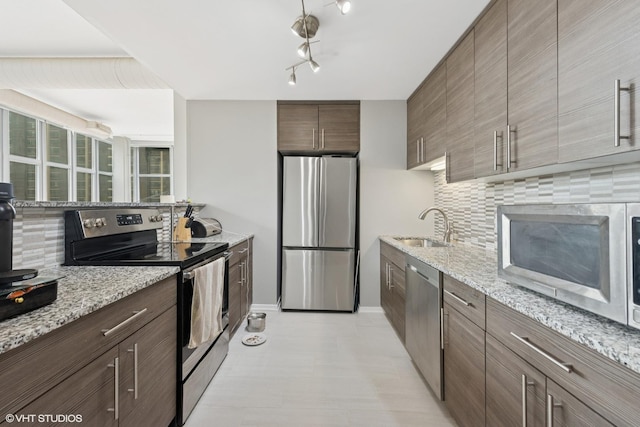 1000 W Leland Ave Unit 5C, Chicago, IL 60640 - kitchen featuring stainless steel appliances, a sink, backsplash, and light stone countertops