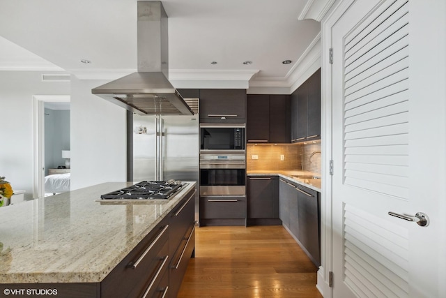 2550 N Lakeview Ave Unit N903, Chicago, IL 60614 - kitchen with built in appliances, island exhaust hood, ornamental molding, tasteful backsplash, and light stone counters
