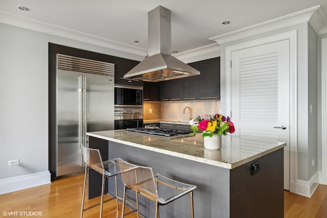 2550 N Lakeview Ave Unit N903, Chicago, IL 60614 - kitchen with island exhaust hood, stainless steel appliances, tasteful backsplash, ornamental molding, and light wood finished floors